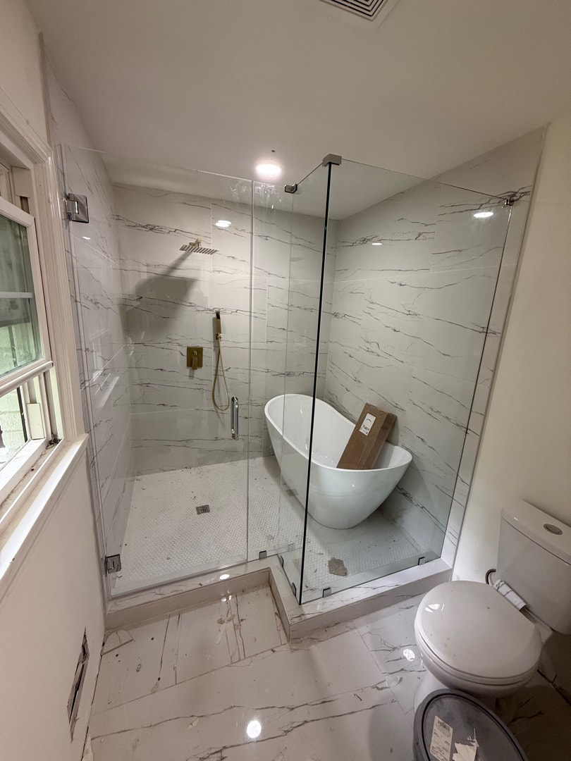 Marble bathroom with frameless glass shower enclosure